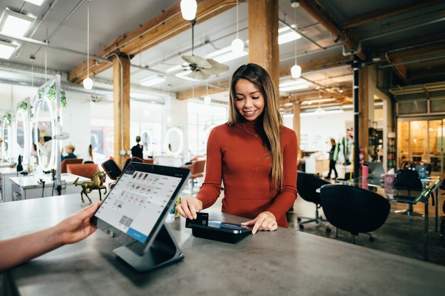 Shop owner taking a card payment at the counter while a customer checks out